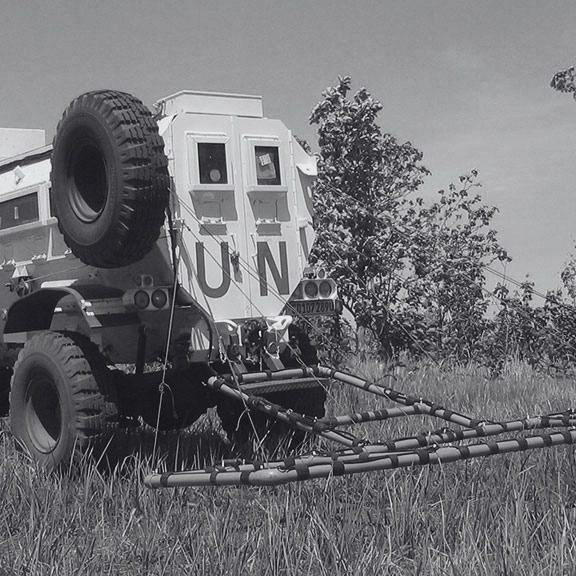 UN vehicle fitted with an Ebinger large-loop detection system for rapid UXO surveying across open terrain.