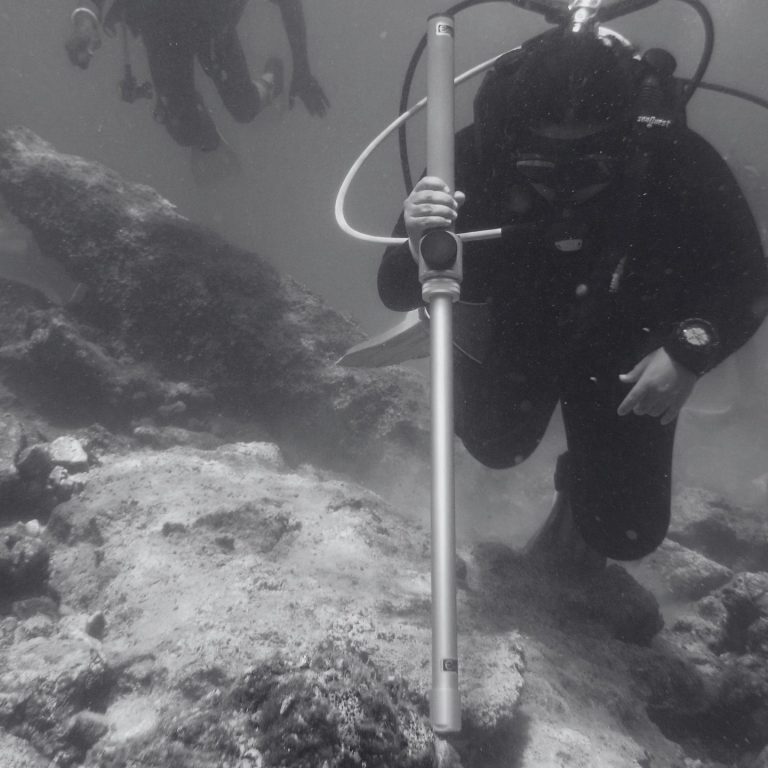 Diver using an Ebinger underwater detector to survey the seabed for buried metal objects.