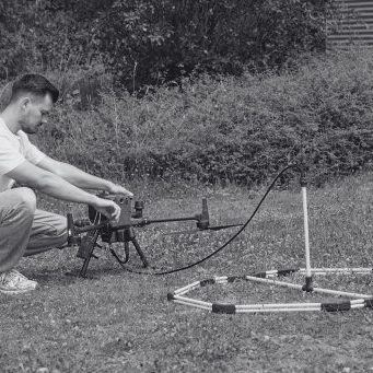 Ebinger VEMOS AIR UAV Sensor Setup Technician preparing an Ebinger VEMOS AIR pulse-induction sensor for a UAV-based detection survey.